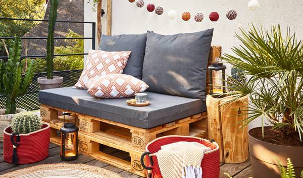 Plus ou moins profond, plus ou moins vif, le rouge se décline en panier, coussin et luminaire pour venir réveiller une banquette grise fait maison - © StudioEvo