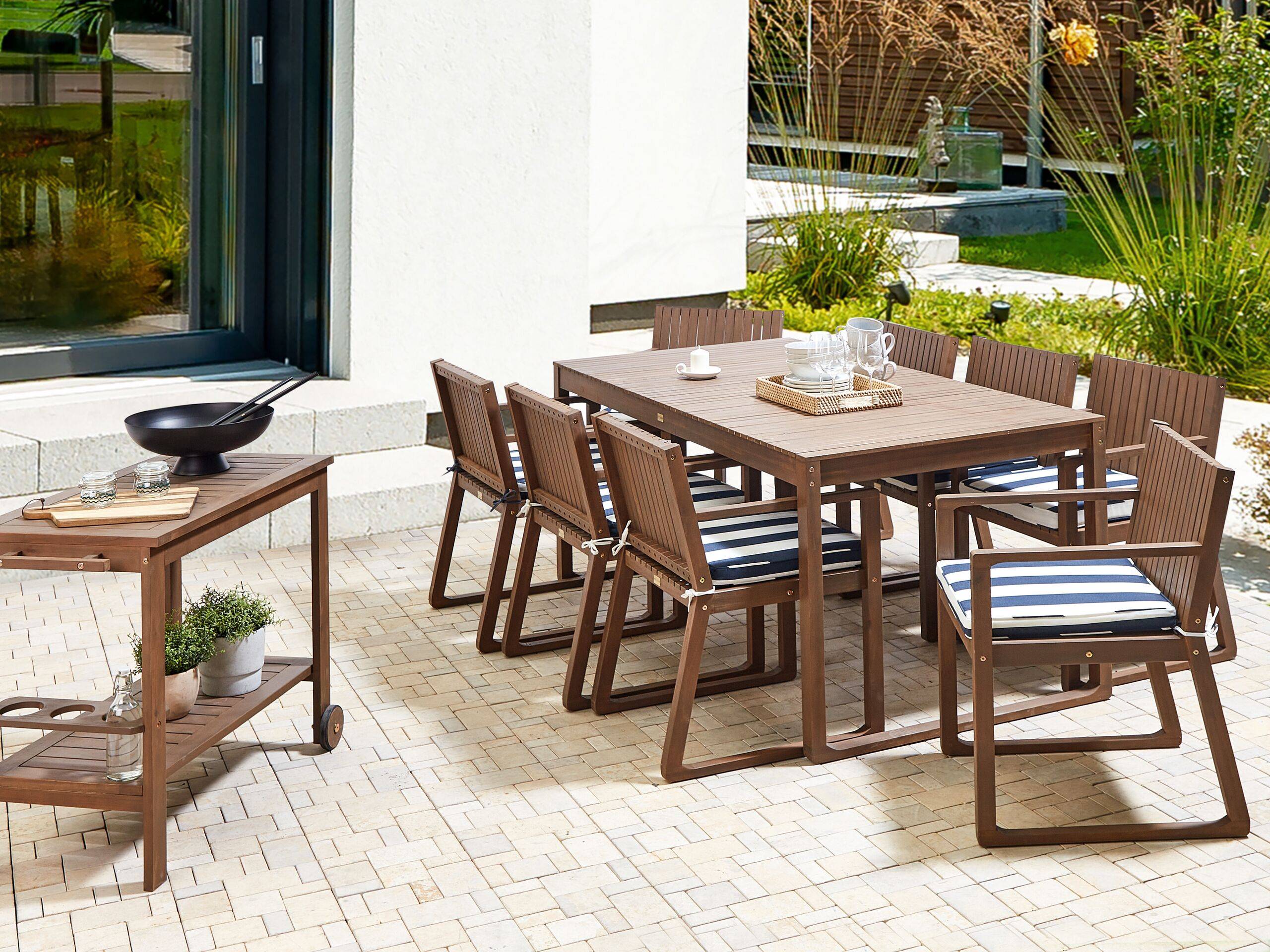 Beliani - Ensemble de Salle à Manger Extérieur Table en Bois d'Acacia Foncé 8 Chaises et Coussins Rayés Bleu Marine Blanc Jardin Rustique - Imagen 2